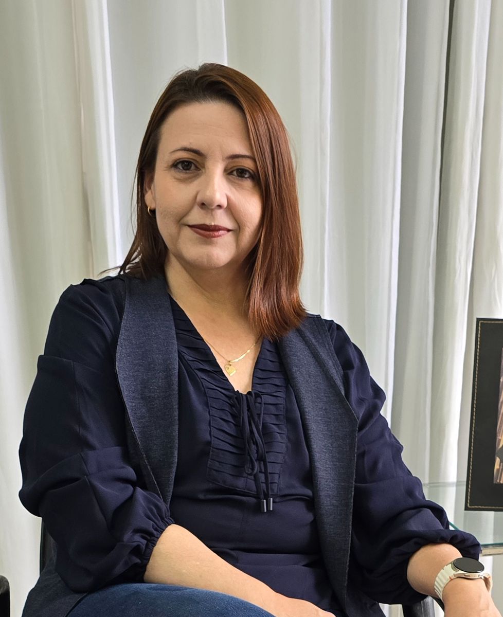 Marisa Moura no consultório, de blazer azul-marinho